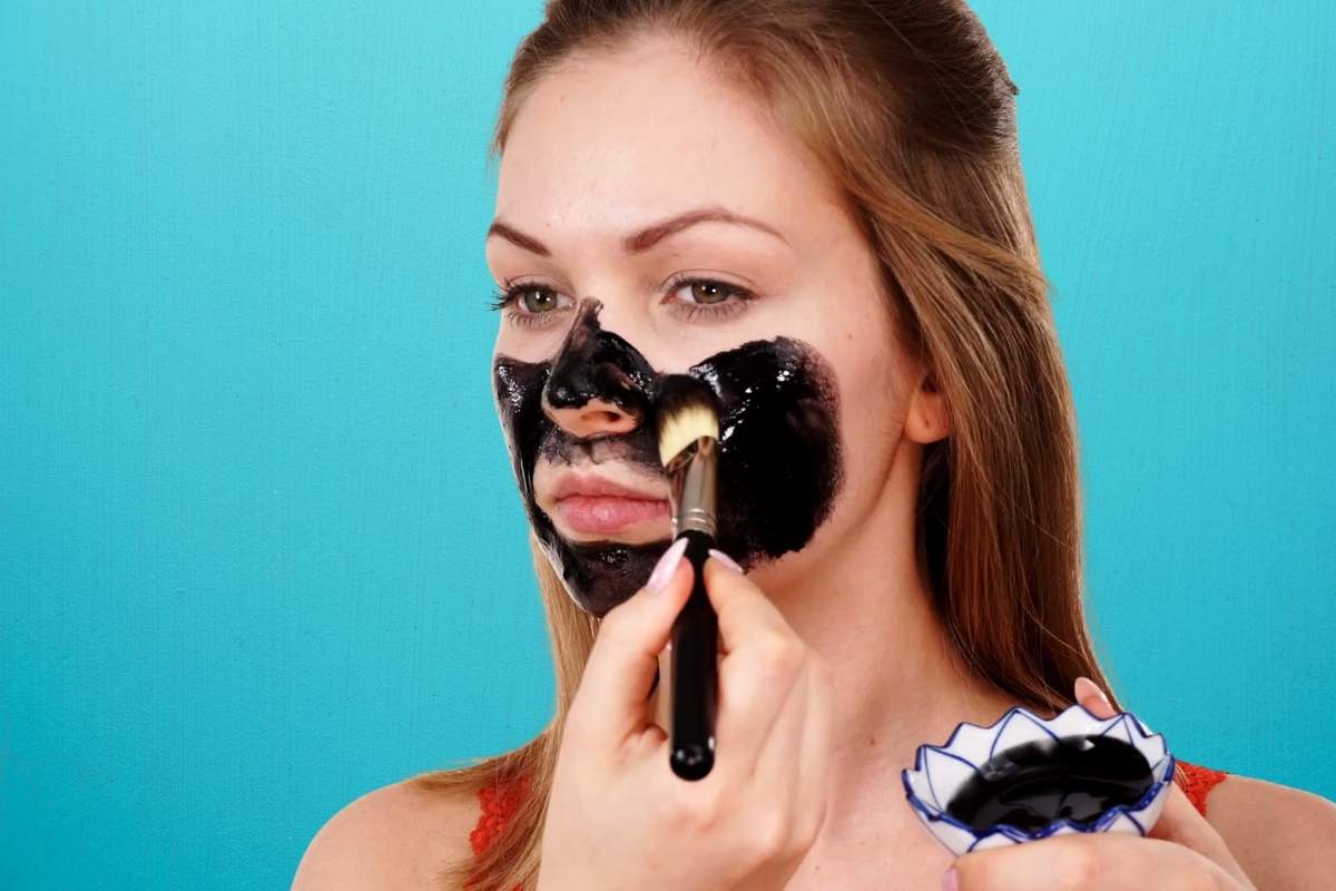devojka stavlja crnu masku na lice